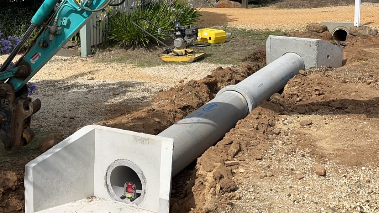 Concrete drainage pipe and pit laid in a freshly dug trench